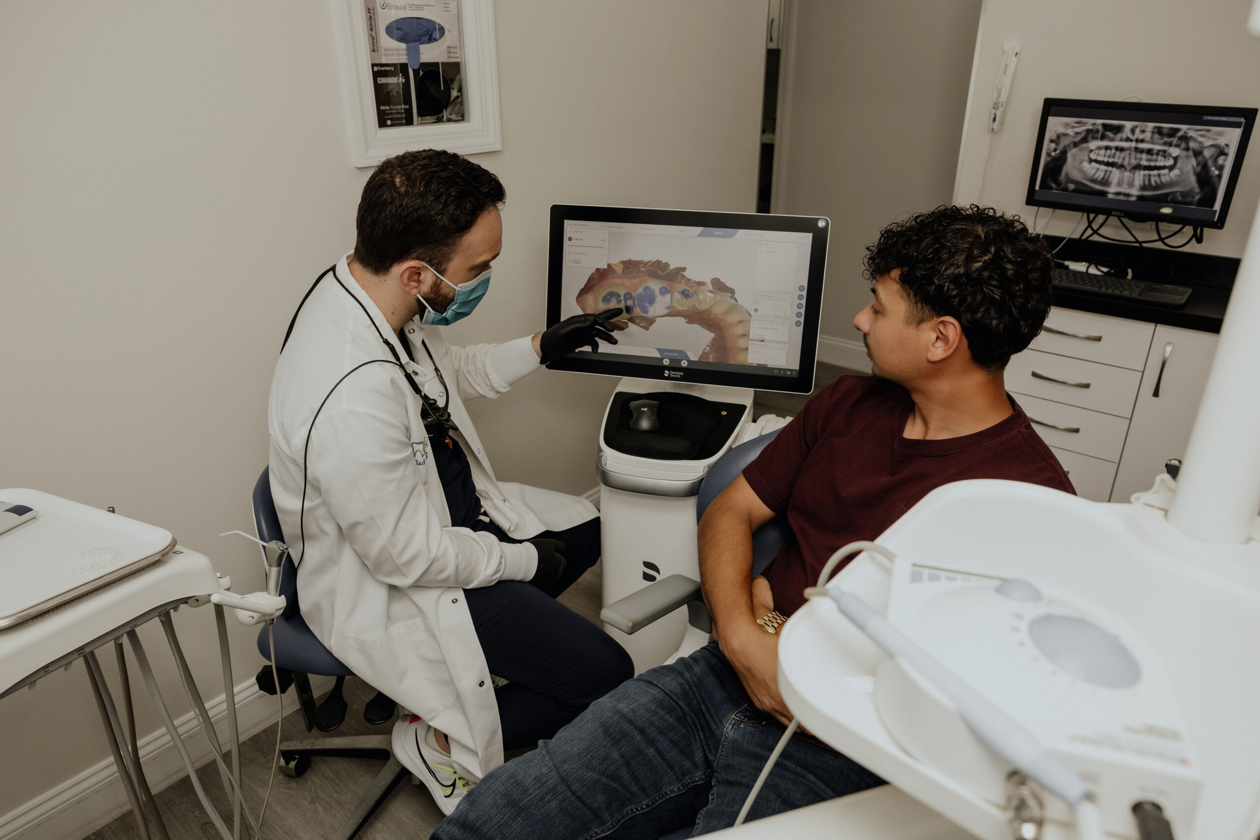 Dentist reviewing digital Invisalign treatment plan with a patient during an orthodontic consultation.