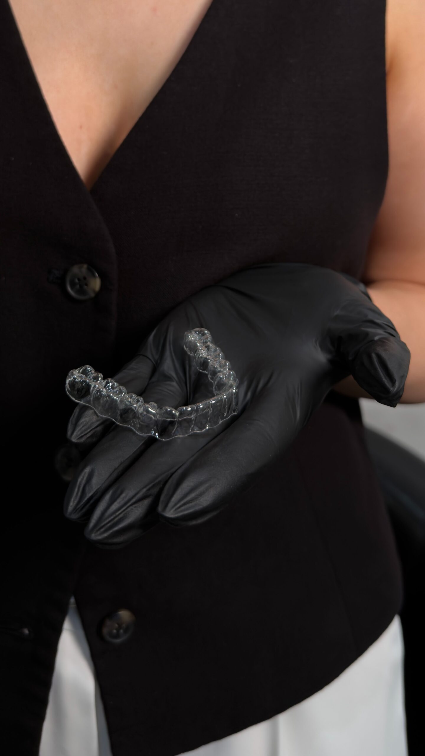 Adult holding clear Invisalign aligners before treatment for a discreet alternative to traditional braces